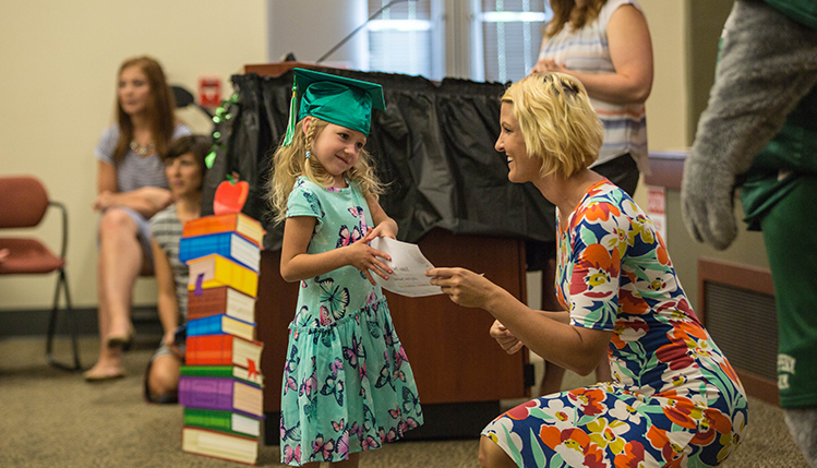 a child being given her degree by a teacher