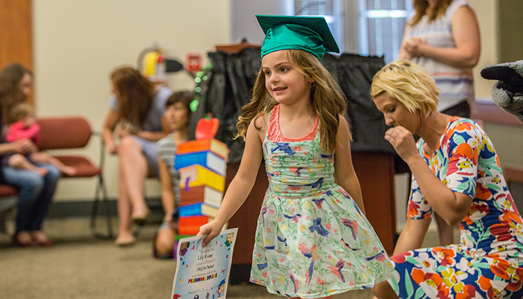 a child holding her degree