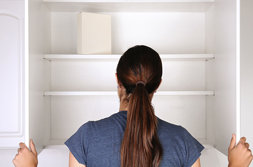 woman in front of an empty cupboard