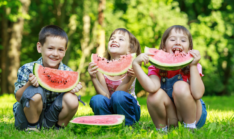 kids eating watermelon in the park
