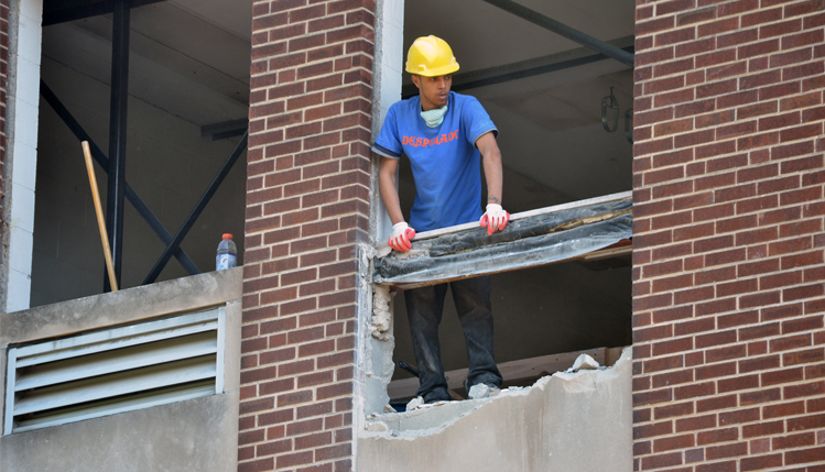 Worker removing brick from Spotts south wall