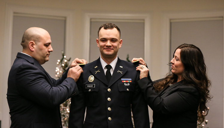 Cadet's parents pin on his officer bars