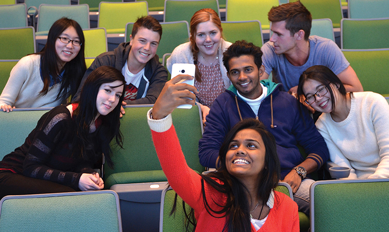 happy students of diversity taking a group selfie