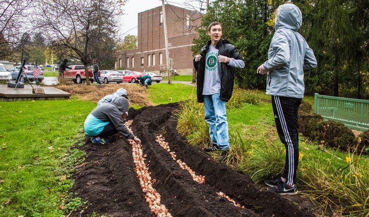 smiling students plant tulips