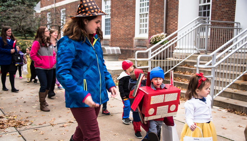 Group of kids walking on sidewalk dressed in Halloween costumes