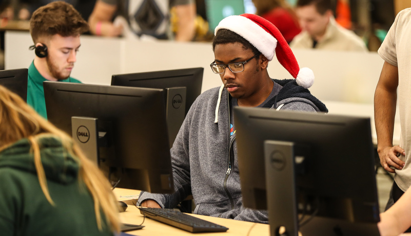 Student working on a computer wearing a santa hat