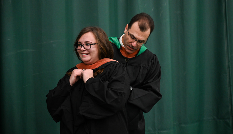 Graduate gets help with her hood