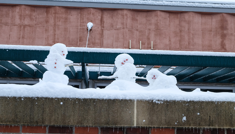 Three snow men on a ledge