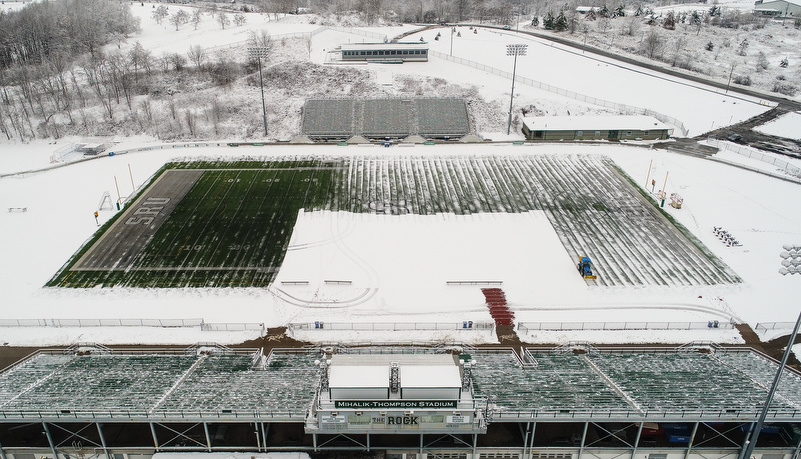 Matainence removes the snow from the football field