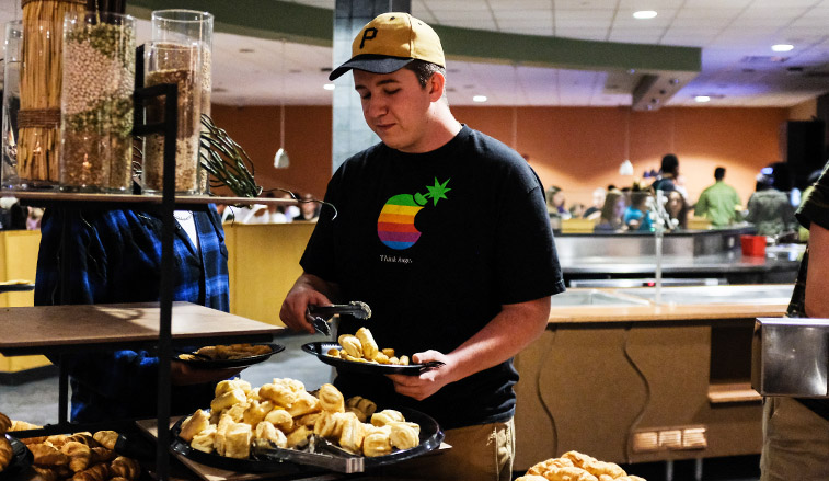 Student selectiing food in Boozel dining hall