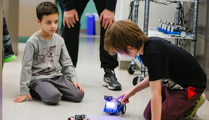 two children playing with robot