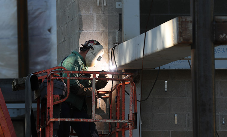 Welding working on the steel structure of Miller Auditorium