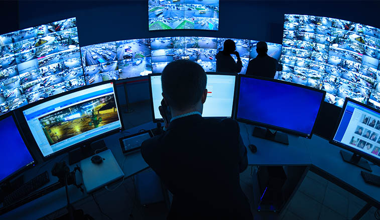 Man working behind CCTV monitors