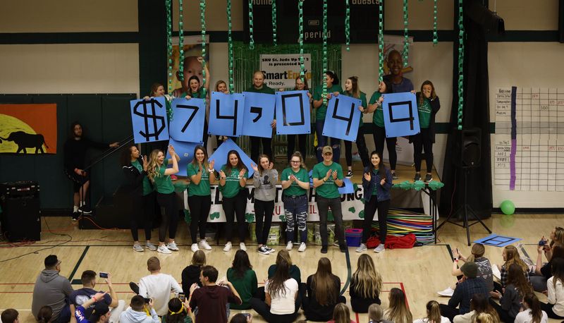 Students holding signs to show total amount fundraised of $74,049