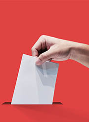 Hand placing a ballot in a ballot box