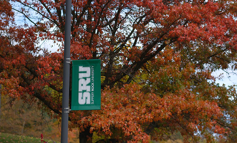 Campus sign in front of fall colors