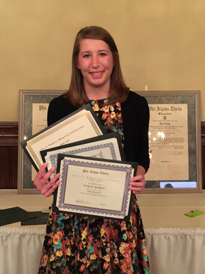 Erin Dempsey smiling with Chapter awards.