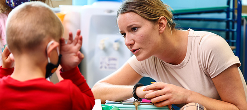 A teacher helps a young student