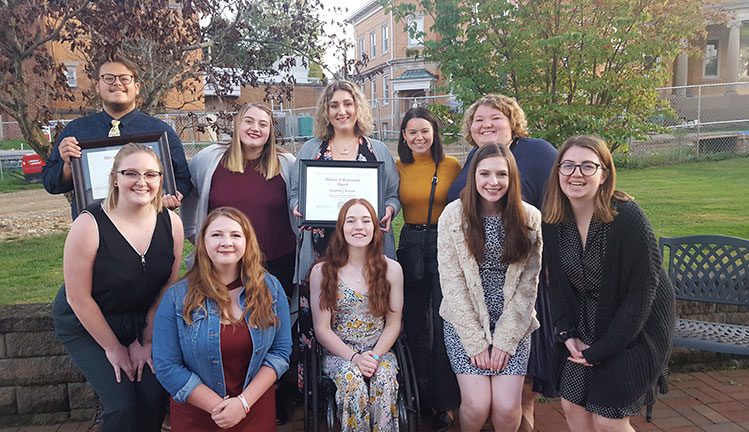 students posing with plaques