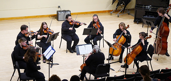 A group of musicians performing in a concert hall.
