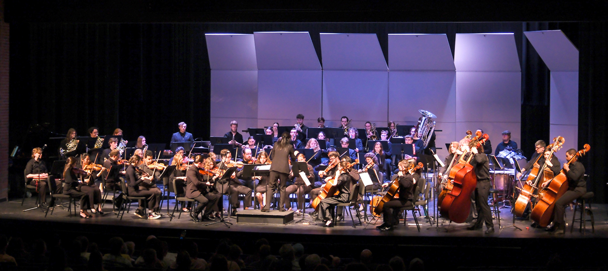 Full orchestra playing concert in recital hall