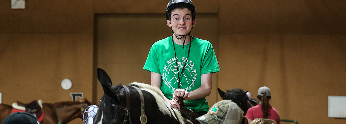 A young man riding on a horse.