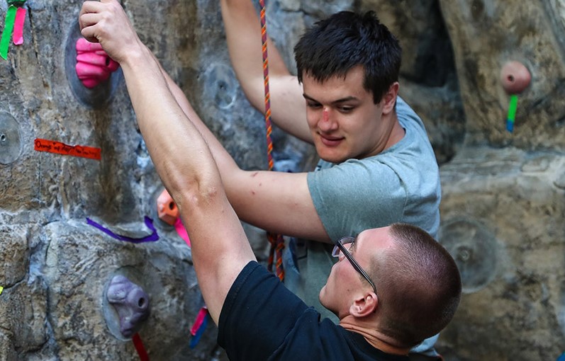Two young men rock climbing.
