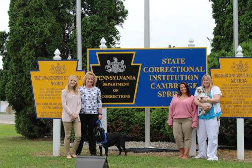 People posing with Department of Corrections sign