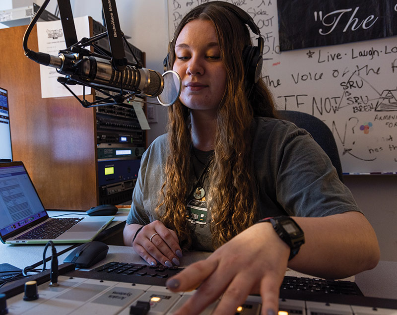 Student using mixing board and microphone