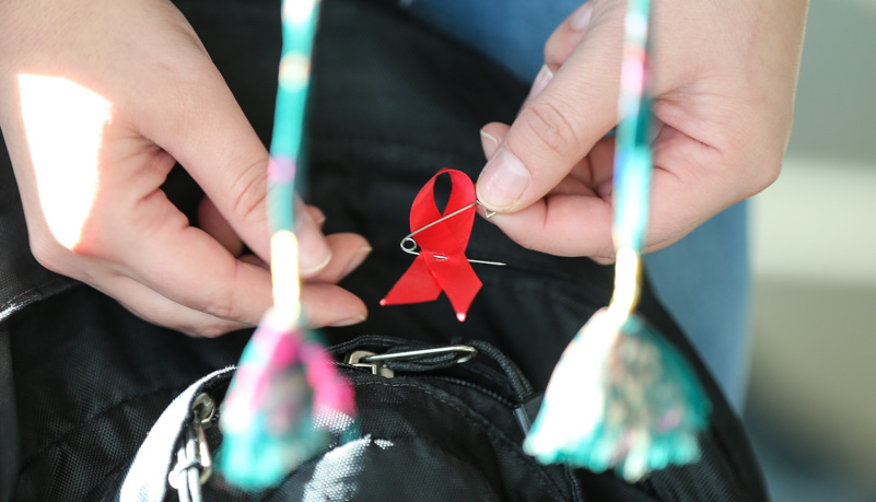 Woman placing an AIDS pin