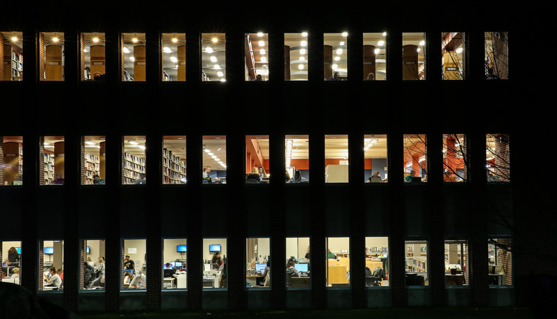Students studying in the library after dark