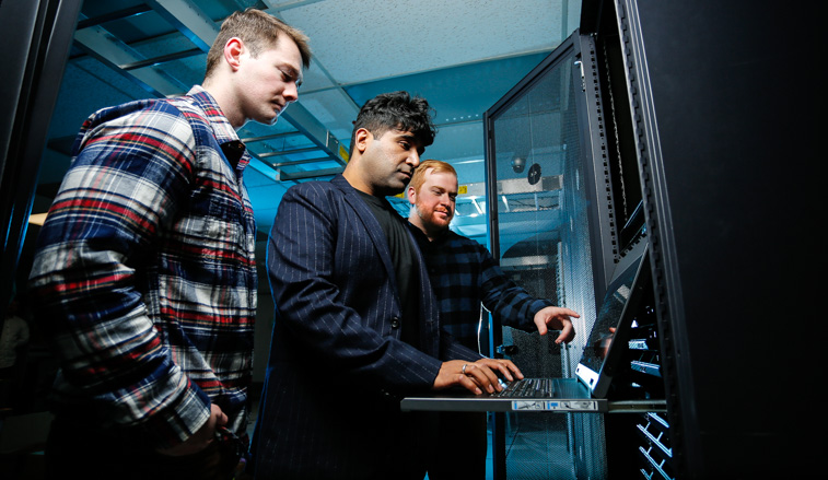 Students and a professor working on a mainframe