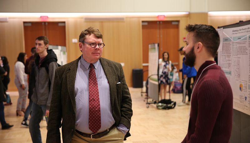 Two men speaking at a symposium