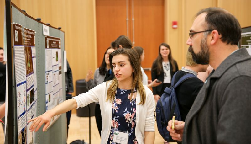 Student explaining her findings at the symposium