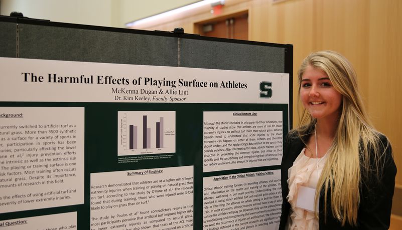 Girl presenting findings on the harmful effects of playing surface on athletes