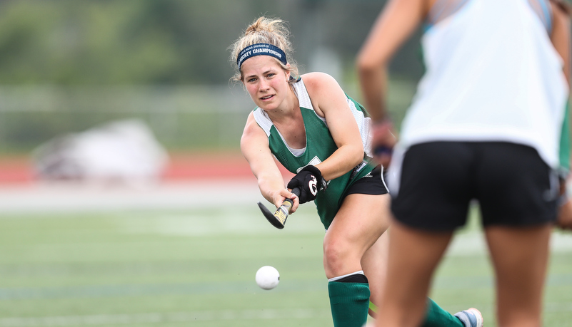 Women playing field hockey