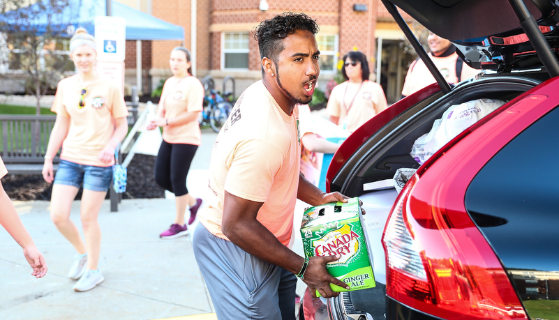 Student helping freshmen move in