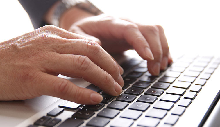 Hands on a keyboard typing a password