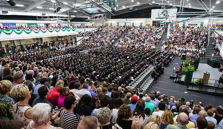 graduates sitting during commencement in the spring