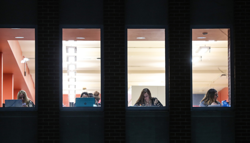 students studying in the library through a window