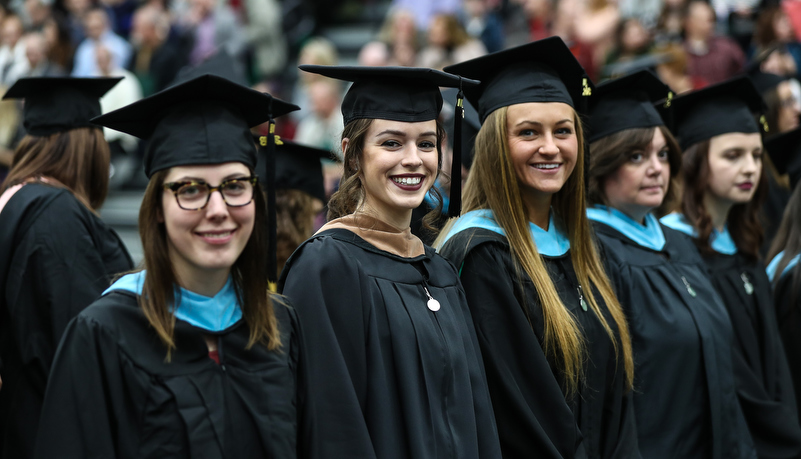 gradutes wait to reciever their diploma