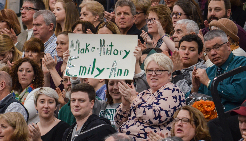 Grandparents hold up a sign