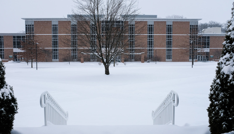 Science building through the trees and snow