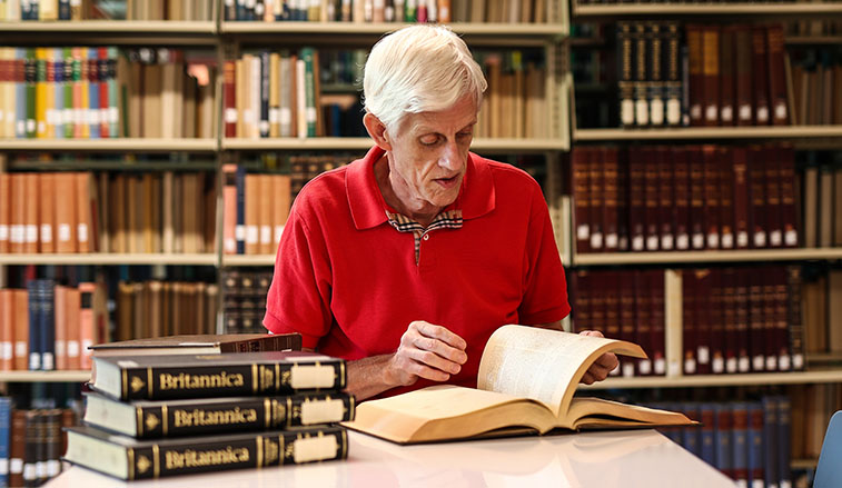 Libraian inspecting an encyclopedia