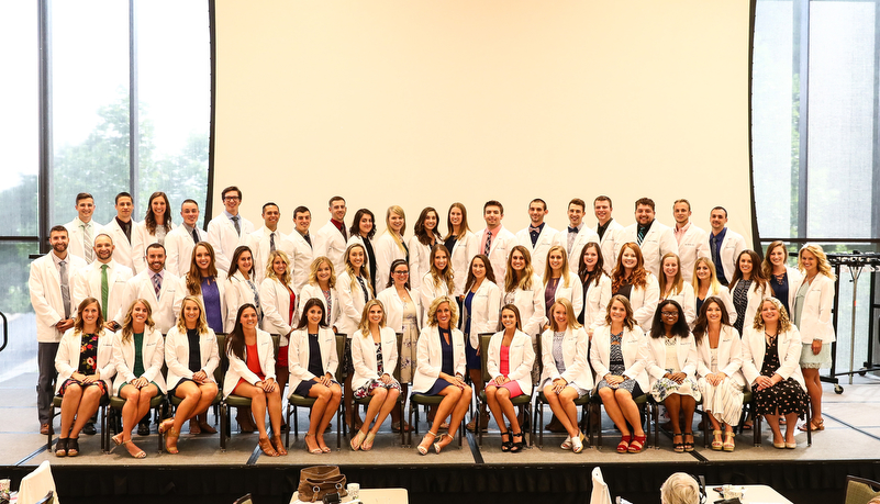 Group photo of the class with their white coats
