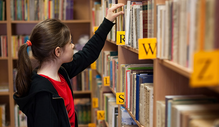 Girl selecting a book in a library