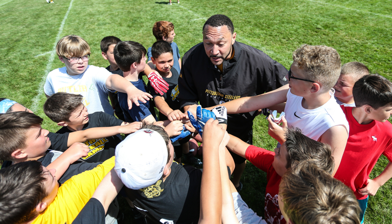 Charlie Batch with kids in a huddle
