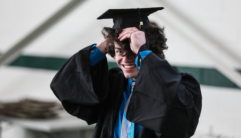 gradute adjusting his hat