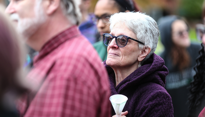 an older woman holding a candle