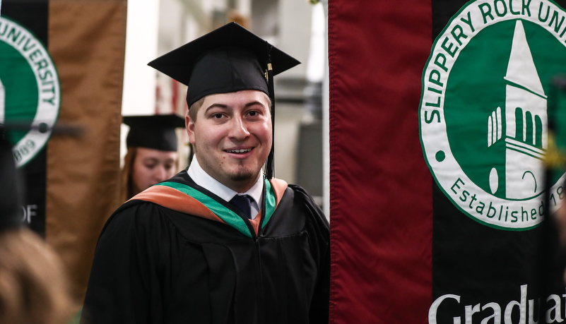 Man with the graduate studies banner